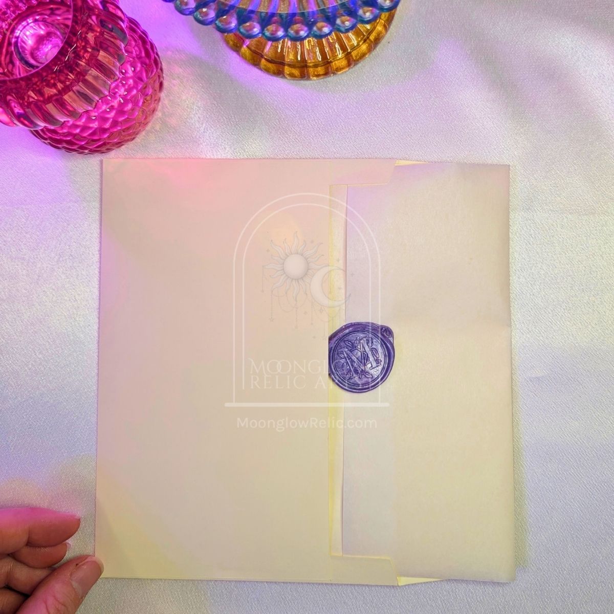 Moonglow Relic sealed charm card tucked into its mailing envelope
